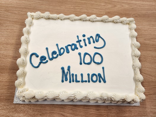 A cake with icing that reads 'celebrating 100 million'