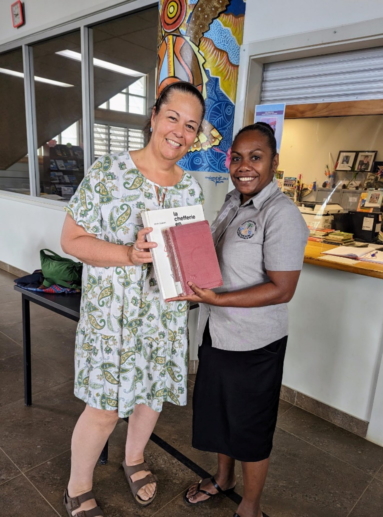 Photograph of Jacky Clements and Nelly Caleb, holding a book and smiling